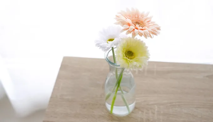 窓際のテーブルの上の花瓶に入った花